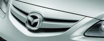 A symbol of mazda in front of a silver bumper