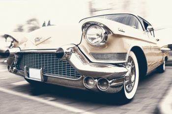 A cream colored front face of the car with a chromed steel bumper